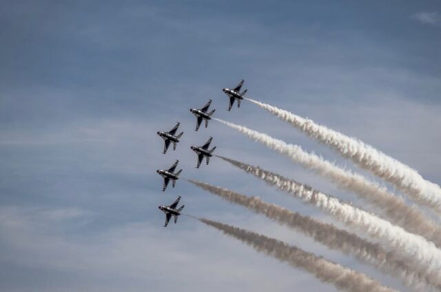 Six jets banking in formation with long white smoke trails